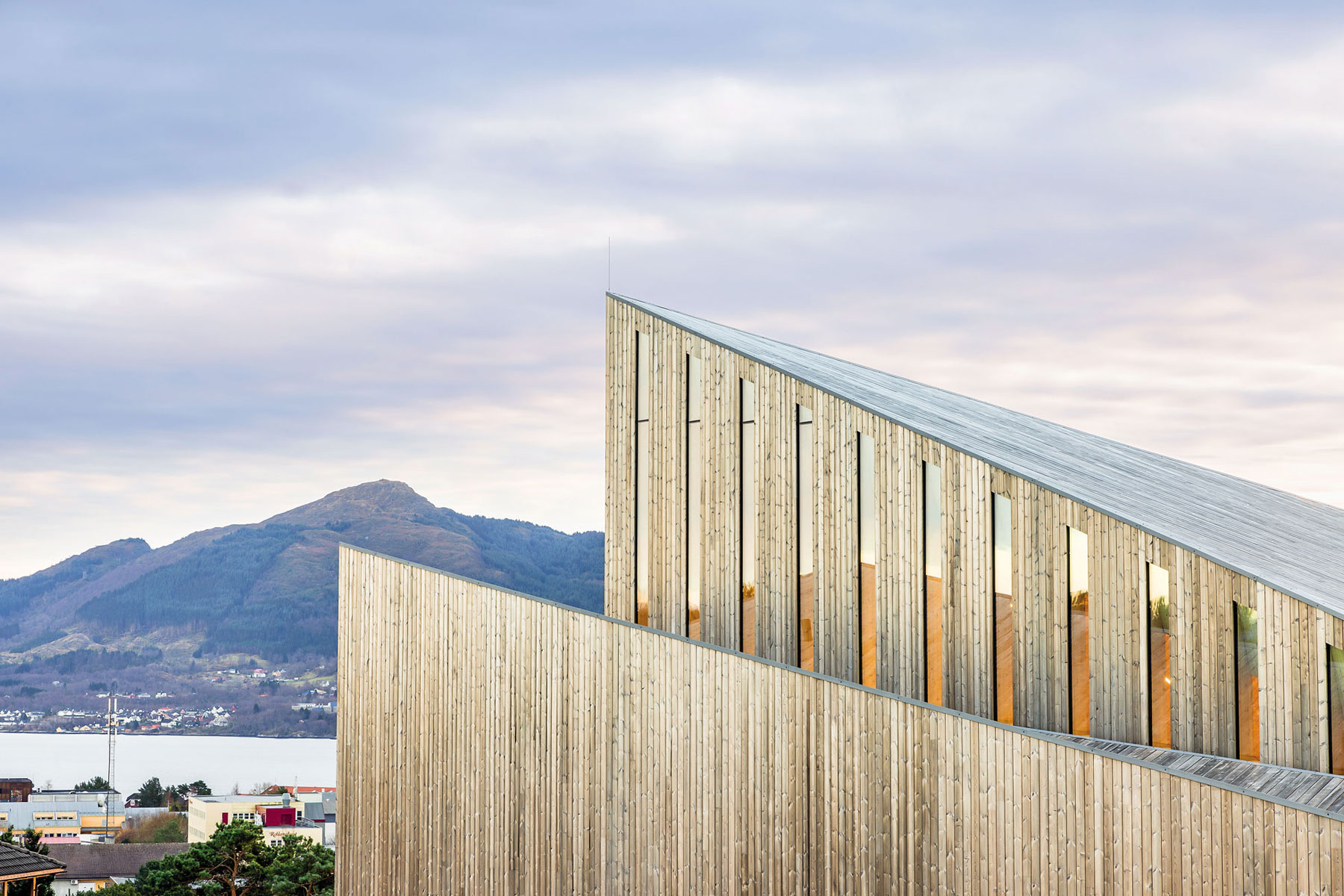 Prísnu lineárnosť strechy odľahčuje drevený fasádny obklad.