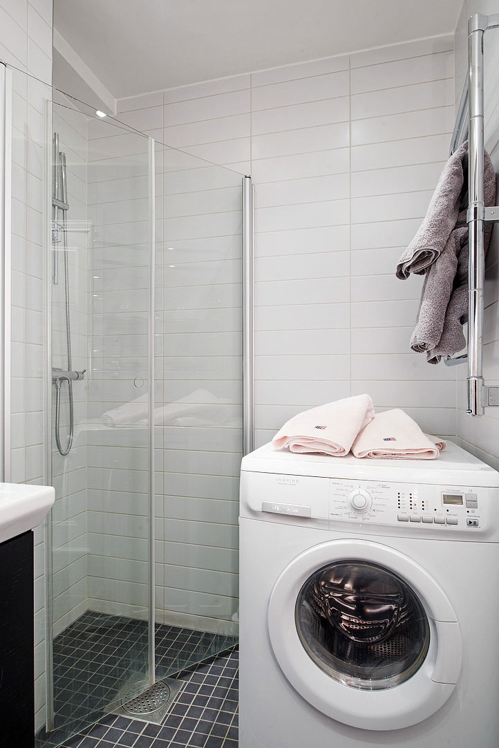Kombinovaná práčka so sušičkou stojí vedľa preskleného sprchového kúta.