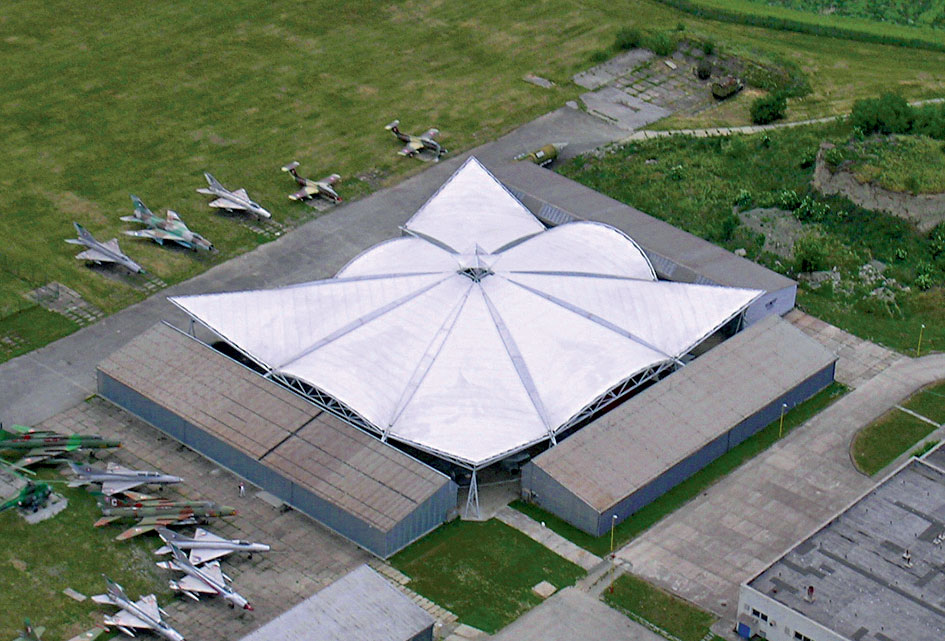 Letecké múzeum  Membránová predpätá strecha leteckého múzea v Košiciach z lietadla pripomína plastickú vrtuľu. Je výborným príkladom riešenia odvážneho konceptu a úspešnej realizácie rozmerného zastrešenia otvorenej expozície lietadiel na ploche 2 920 m2, maximálna výška zastrešenia je 13,5 m. Primárna nosná konštrukcia je vytvorená z priehradových oceľových rúrkových stĺpov a nosníkov v kombinácii s oblúkovými rámami a lanovými ťahadlami. Na výrobu ôsmich veľkoplošných predpätých membrán bol použitý kompozitný textilný materiál Ferrari Précontraint 1302 Fluotop T2. Úspešný projekt čaká na druhú časť realizácie – zastrešenie druhého dvora, ktorý tvoria pôvodné budovy leteckých hangárov.  Miesto: Košice Autor projektu stavby: Ing. arch. Martin Drahovský Autor projektu membránových štruktúr:  Ing. arch. Ján Dolejší Dodávateľ membránových štruktúr: COSMEX, a. s.,  a Jiří Konečný – LAUGART