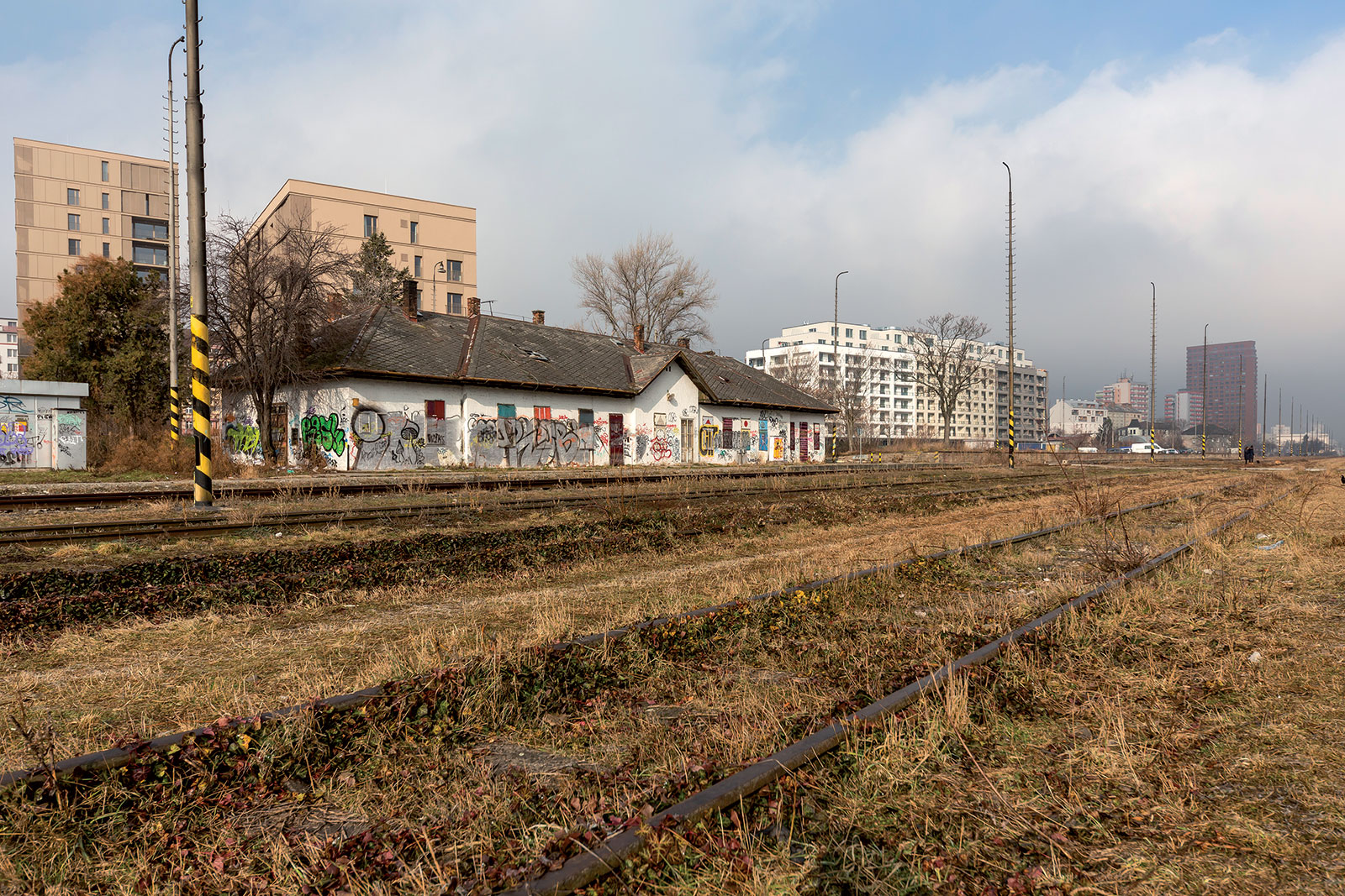 Aktuálne foto chátrajúcej stanice Filiálka v Bratislave – na pozadí sú developerské projekty: zľava Rezidencia pri Mýte, Urban Residence a vpravo v diaľke Manhattan.