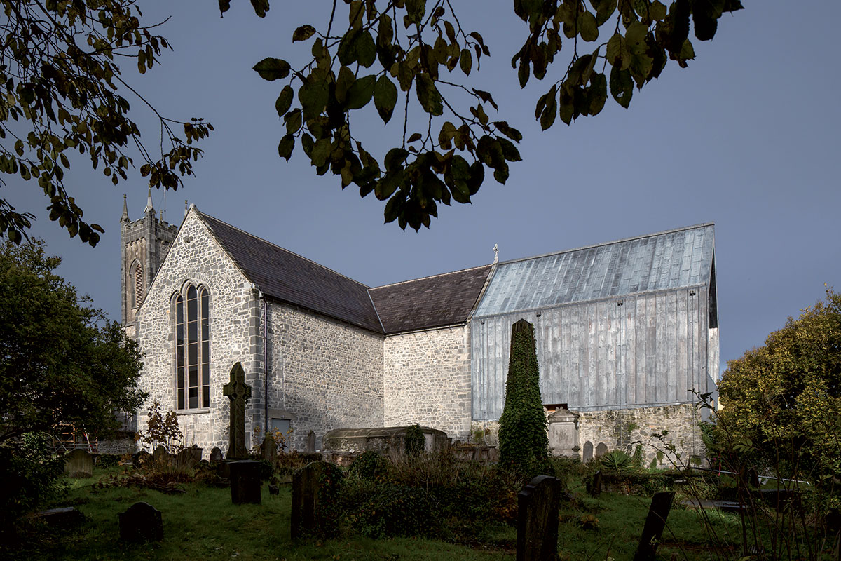 Olovený plech odlišuje nové objemy od staršej hmoty. Dobudované presbytérium obnovilo siluetu kostola.