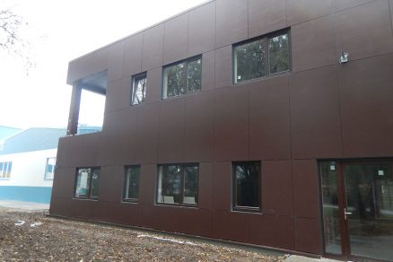 Dvojposchodová administratívna budova so sedlovou strechou má opláštenie vonkajších stien riešené cementotrieskovými doskami CETRIS® FINISH