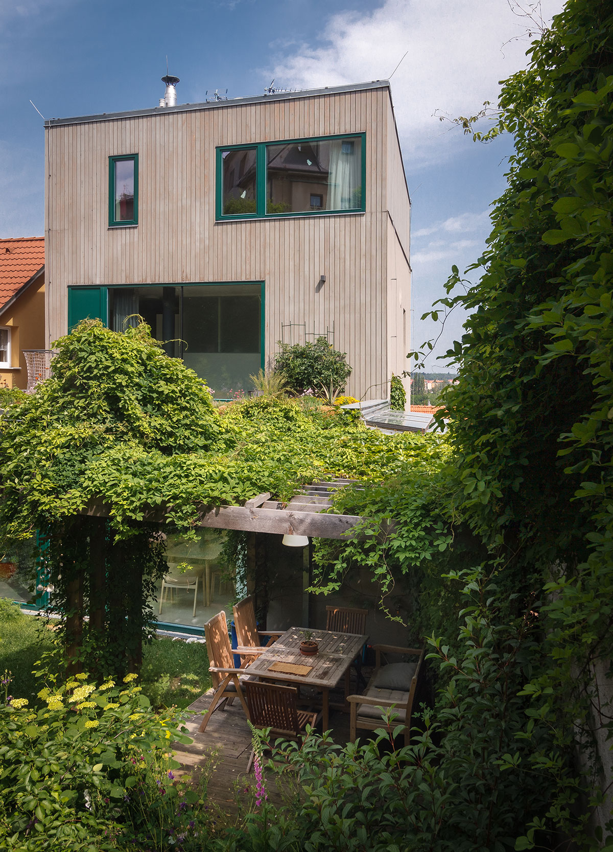 Smerom do záhrady je fasáda domu obložená drevom rovnako