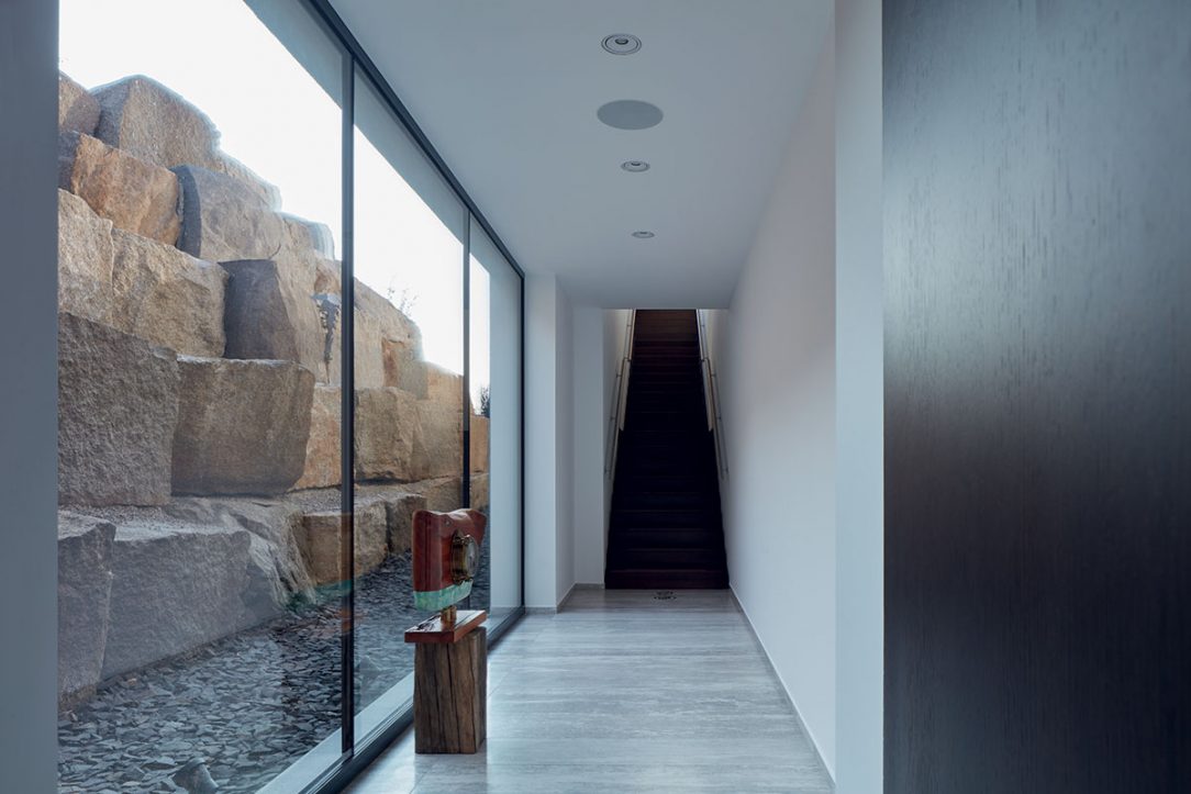 Dizajn postavený na kontraste drsných kamenných balvanov v exteriéri a čistých povrchov v interiéri funguje a vytvára jedinečnú až umeleckú atmosféru