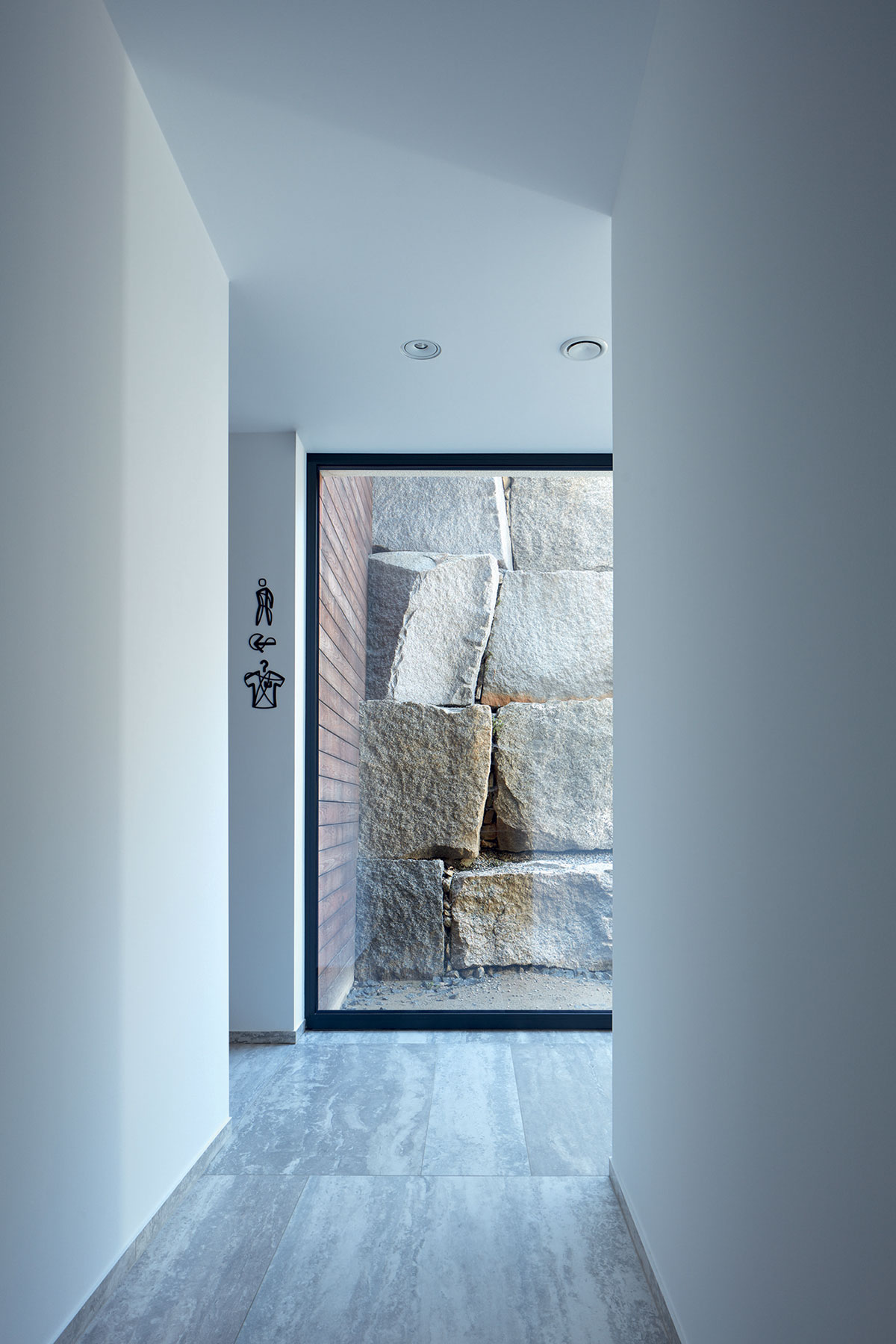 Dizajn postavený na kontraste drsných kamenných balvanov v exteriéri a čistých povrchov v interiéri funguje a vytvára jedinečnú až umeleckú atmosféru.