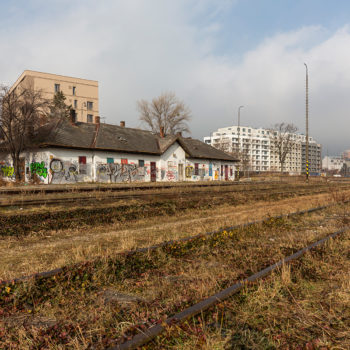 Aktuálne foto chátrajúcej stanice Filiálka v Bratislave – na pozadí sú developerské projekty: zľava Rezidencia pri Mýte, Urban Residence a vpravo v diaľke Manhattan.
