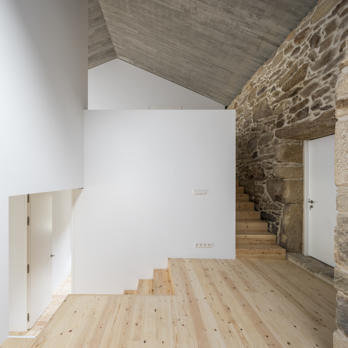 Zjednocujúcim prvkom interiéru je drevo z galícijskej borovice použité na podlahách.