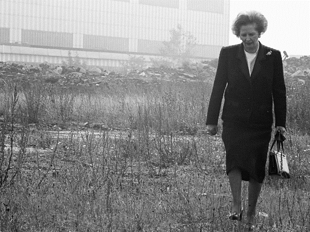 Ikonická fotografia britskej premiérky Margater Thatcher, prechádzajúcej sa pláňami skrachovaných fabrík.