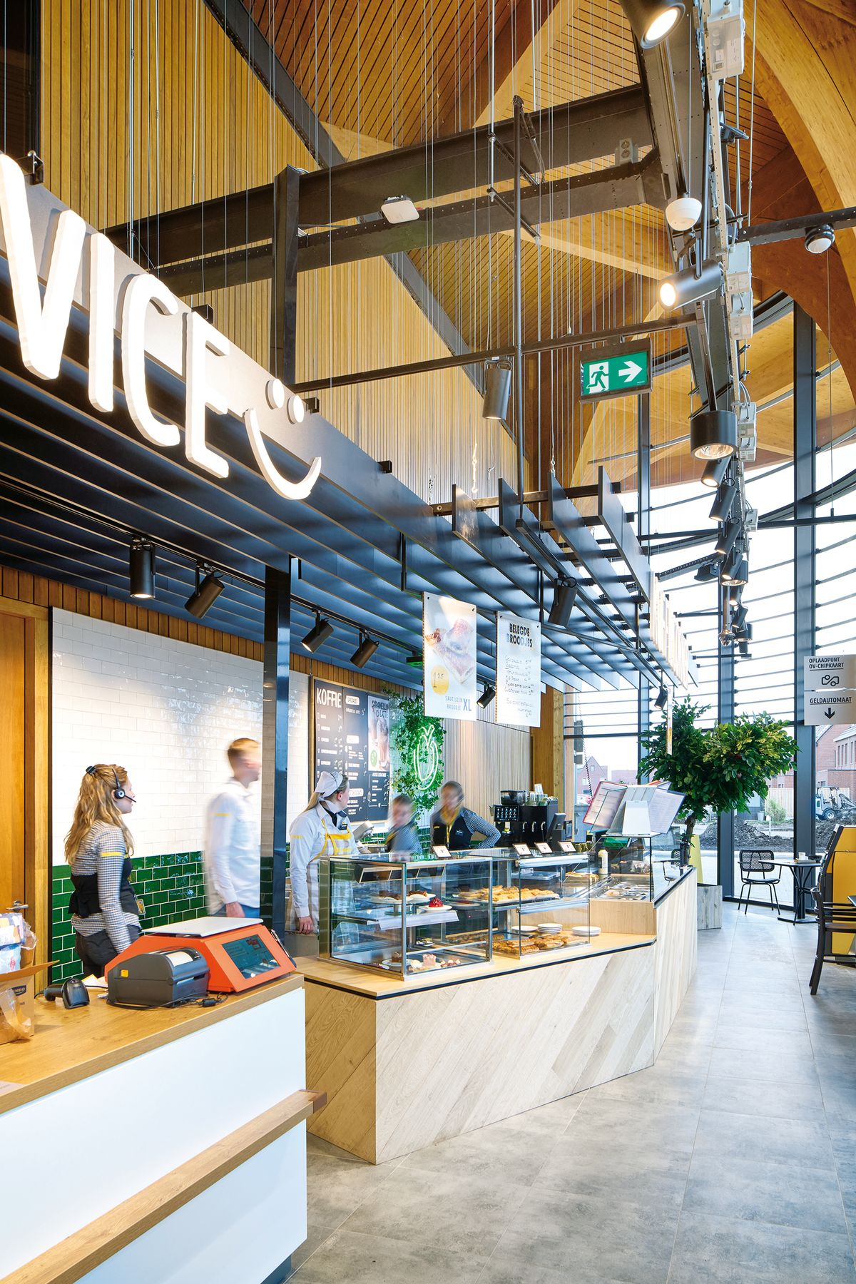 Supermarket v holandskom meste Groningen poňali architekti ako novodobú tržnicu a živé komunitné centrum. Oproti výrazným dreveným klenbám zvolili sivý odtieň dlažby, ktorá je funkčná a zároveň decentná.