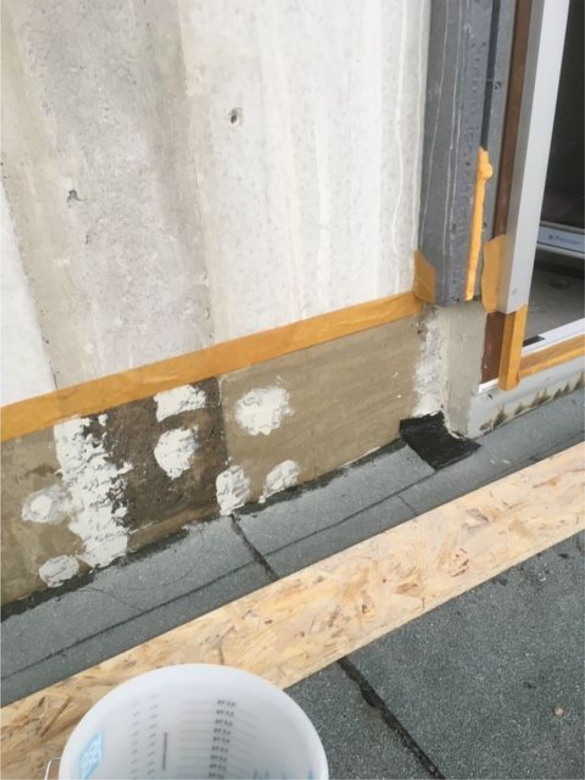 Obr. 1 Ukončenie vrchného asfaltovaného pásu s posypom pri plastovom ráme dverí a steny bez zateplenia.