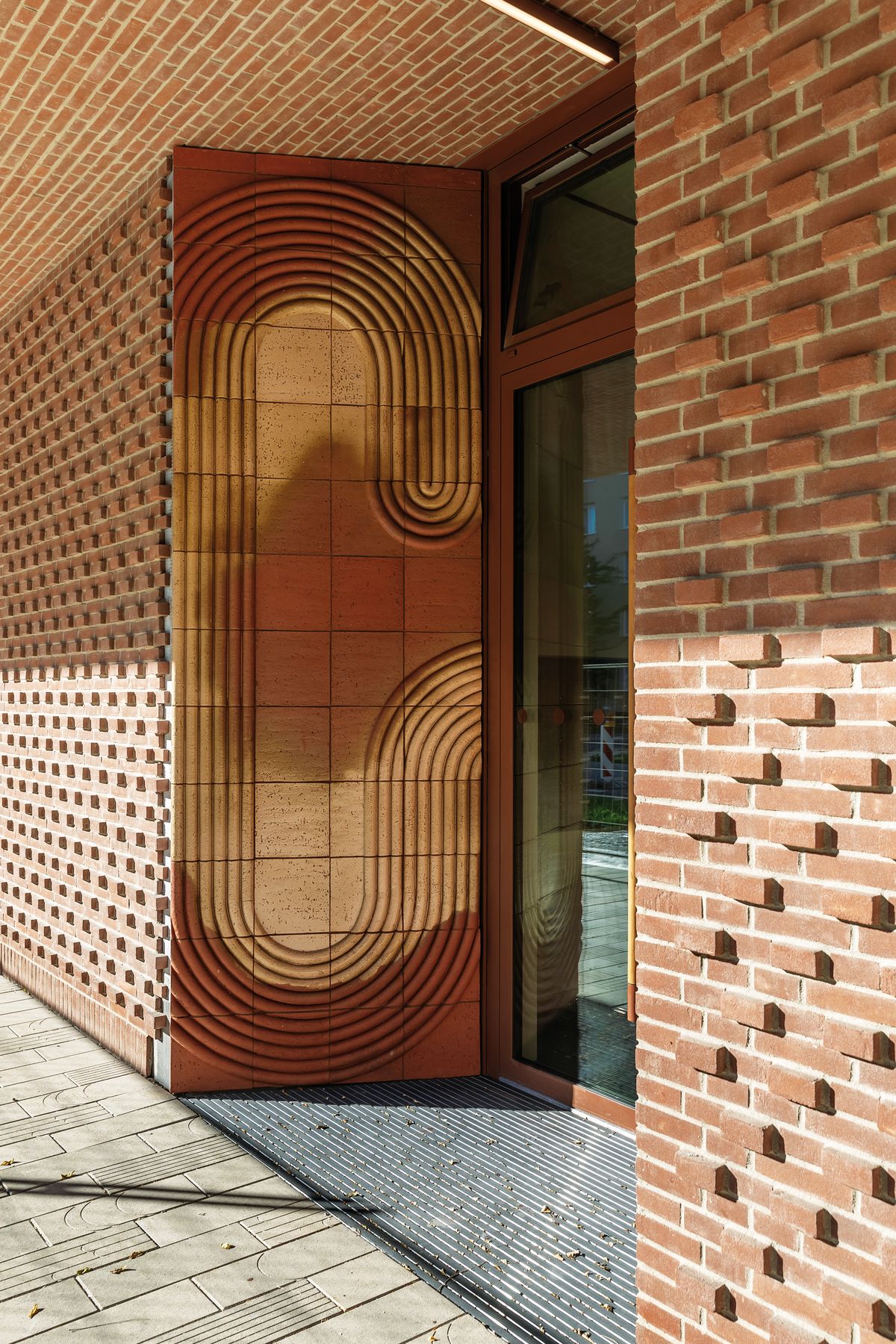 Vstupy do bytového domu ZWIRN 1 definujú umelecké diela od umelkyne Veroniky Selingerovej. Originálnym prvkom je i jedinečné drevené madlo dverí.