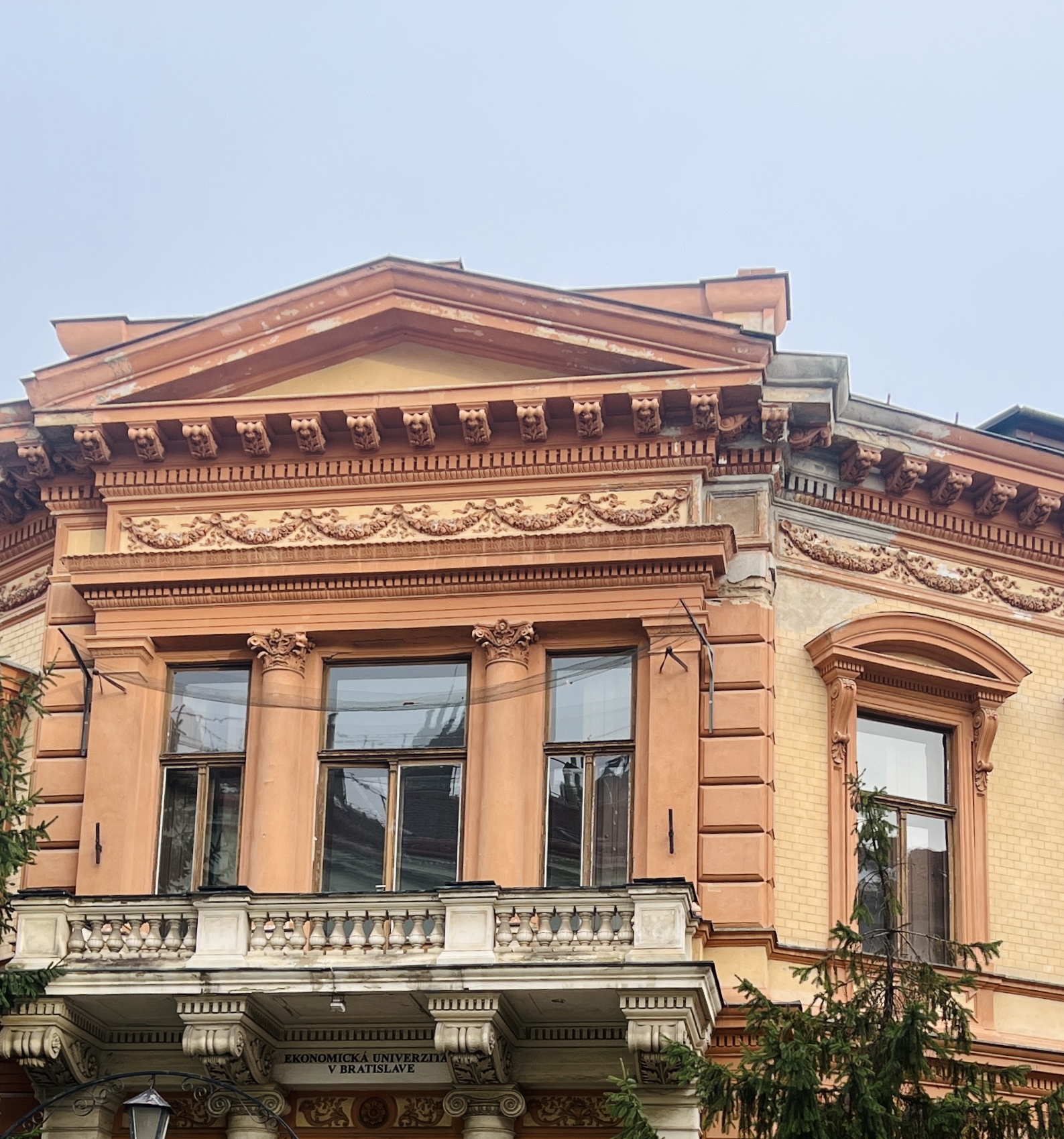 Detail na opadanú fasádu a nainštalovanú sieť nad hlavným balkónom Heckenastovho paláca