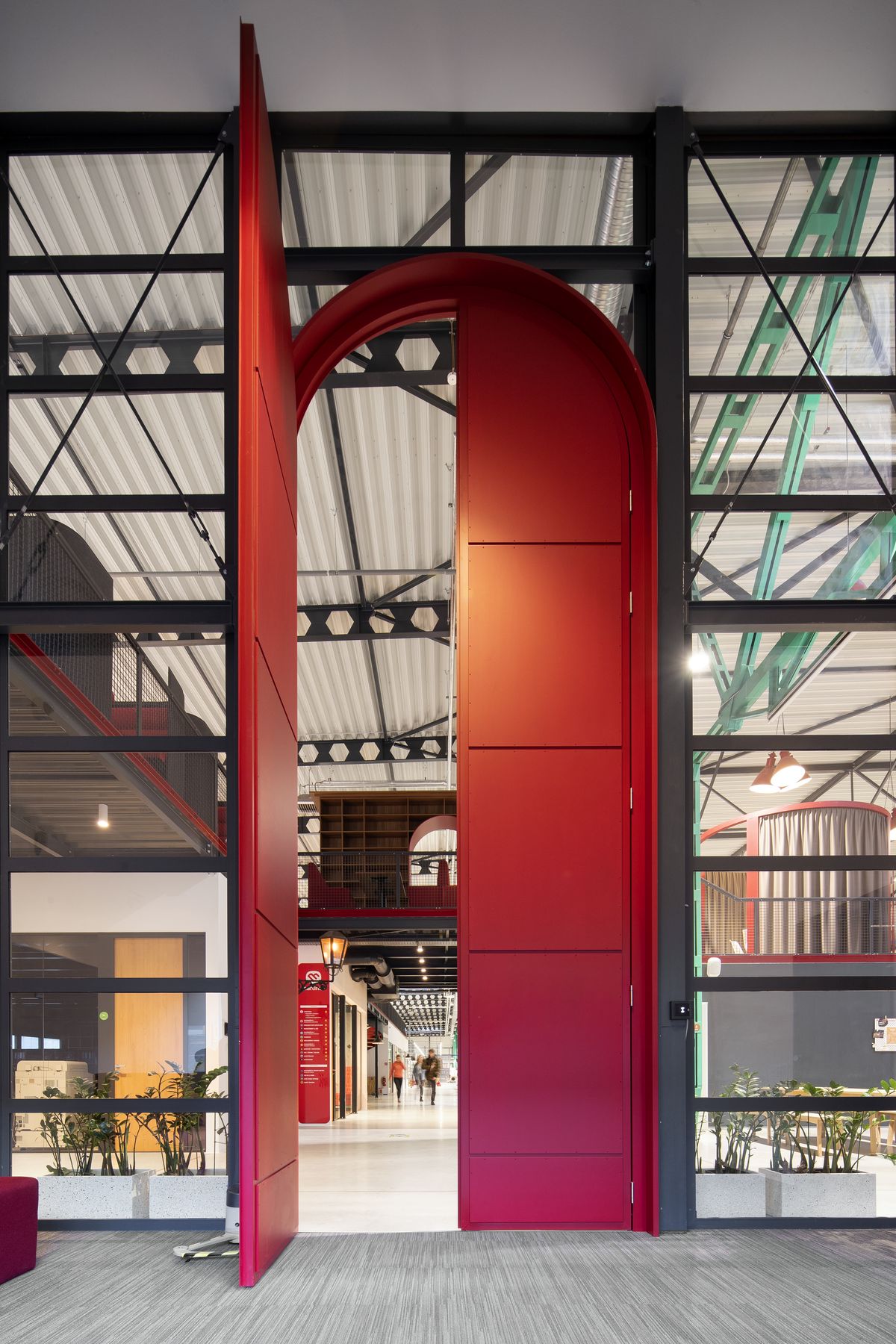 Do otvorenej haly vedie dvojkrídlový portál na celú výšku priestoru, 6,5-metrové červené vstupné dvere odkazujú na knihu Alica v krajine zázrakov. 