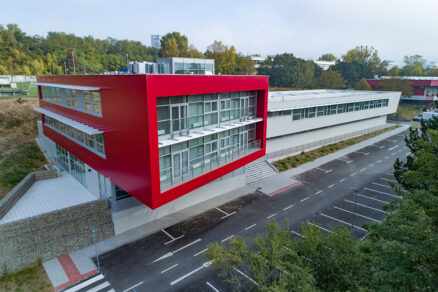 Fasáda pavilónu je definovaná keramickým plášťom a pásovými hliníkovými oknami, ktoré vytvárajú kontrast medzi červenými a sivými odtieňmi aj opticky zvýrazňujú architektonické prvky.