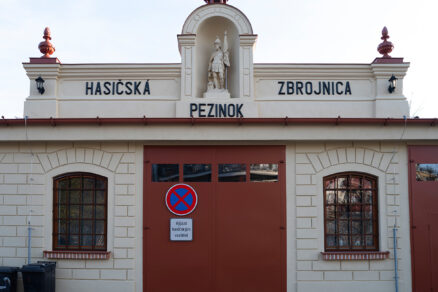 Detail hlavného vstupu hasičskej zbrojnice v Pezinku s nápisom a sochou
