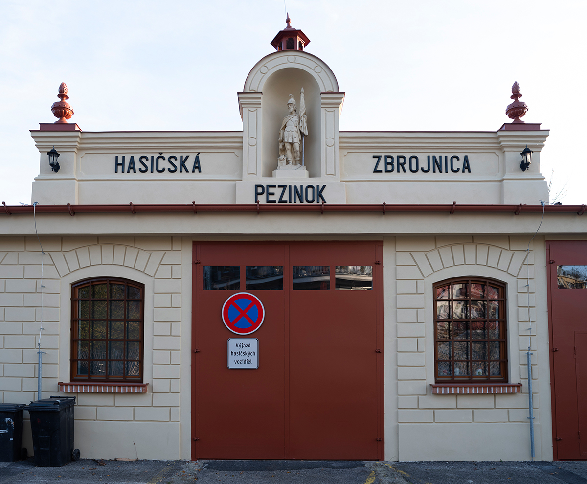 Detail hlavného vstupu hasičskej zbrojnice v Pezinku s nápisom a sochou