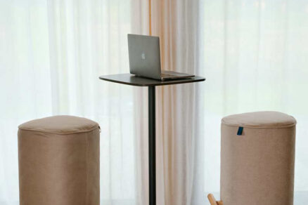 Minimalistické pracovné sedenie s valcovými taburetkami a elegantným stolíkom.