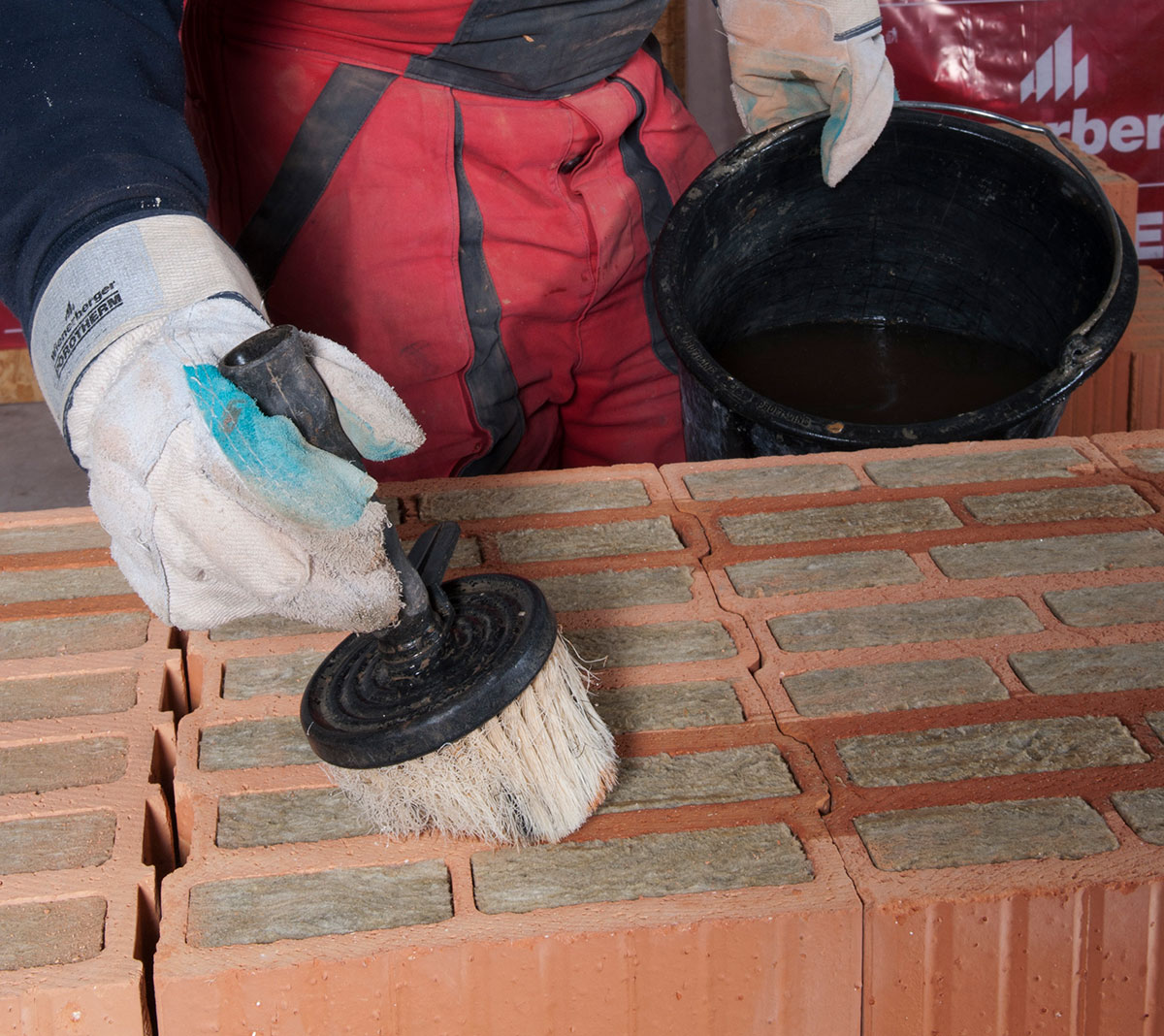 13. Murovanie na penu
Pena sa na tehly plnené minerálnou vlnou nanáša v štyroch pruhoch so šírkou približne 15 mm na prvé dve vnútorné rebrá pri oboch povrchoch muriva. Rebrá treba pred nanesením peny najprv navlhčiť. Pri vlhčení sa nedá vyhnúť kontaktu mokrého štetca s minerálnou vlnou, čo však vďaka jej hydrofobizácii nevadí.