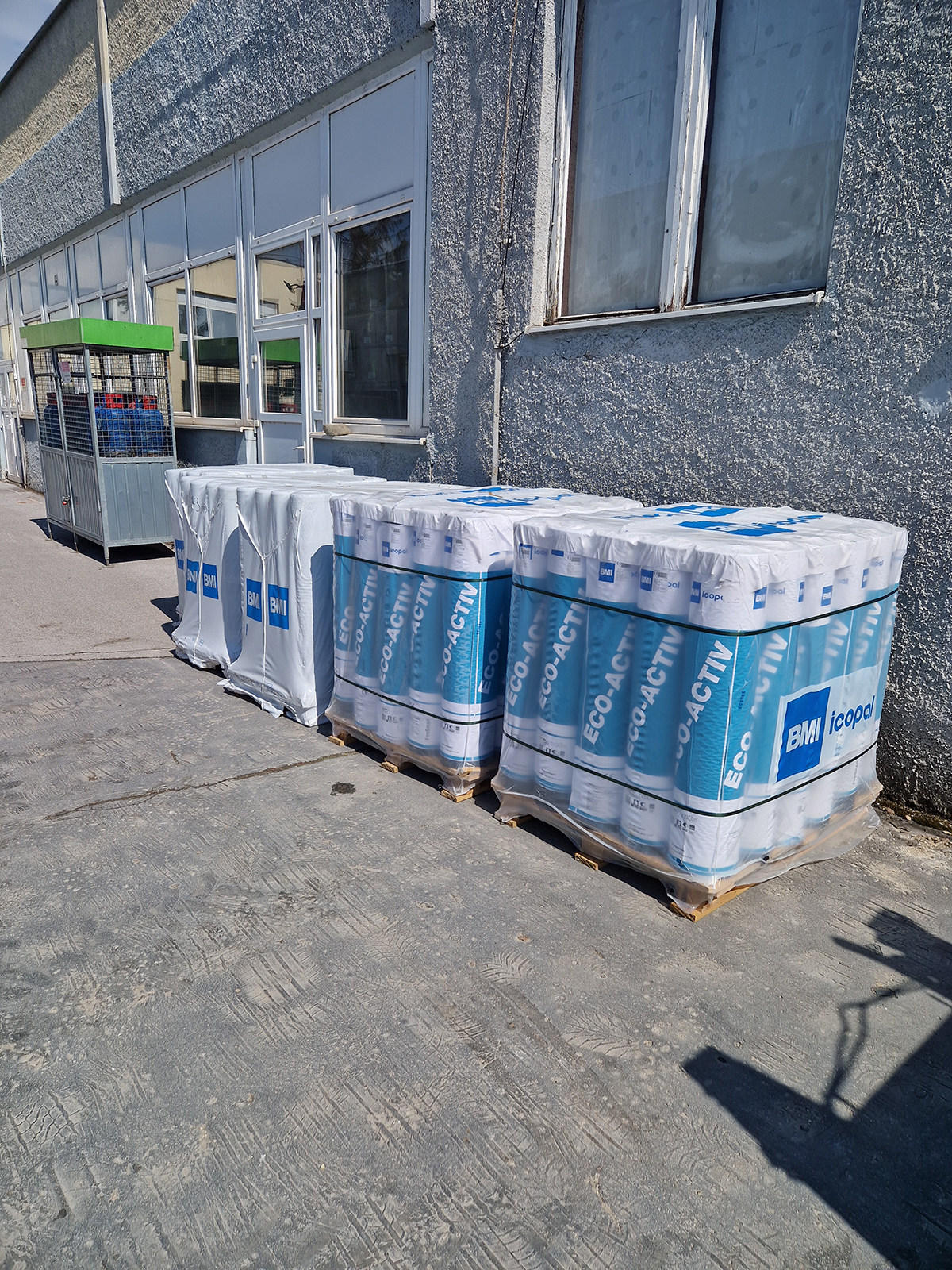 Palety s asfaltovaným hydroizolačným pásom ICOPAL Eco-Activ pripravené na montáž
