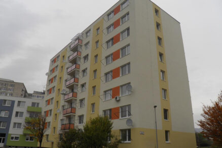 Modernizovaný bytový dom po obnove, zateplená fasáda so satelitmi a novými oknami