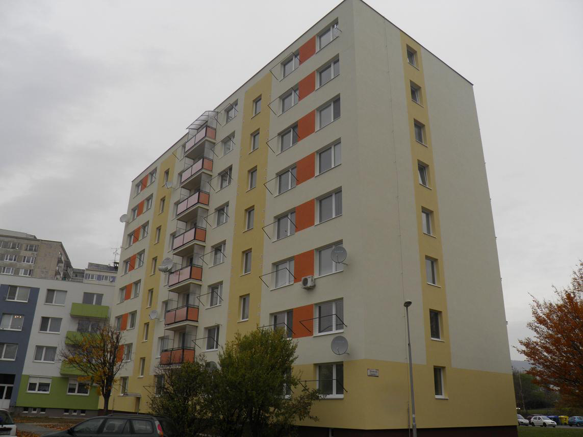 Modernizovaný bytový dom po obnove, zateplená fasáda so satelitmi a novými oknami