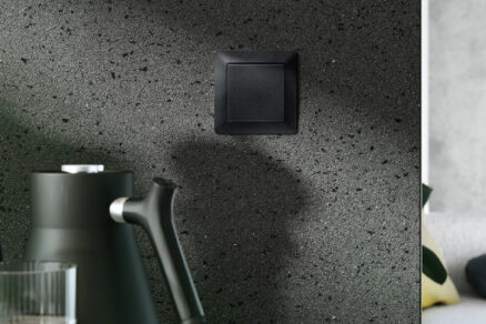 Čierny smart vypínač Zoni® elegantne integrovaný do tmavej kuchynskej steny