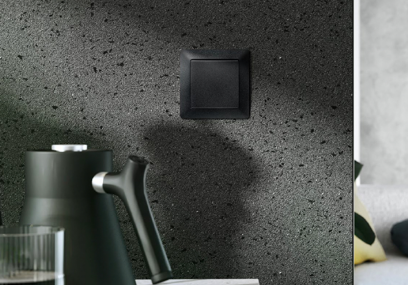 Čierny smart vypínač Zoni® elegantne integrovaný do tmavej kuchynskej steny
