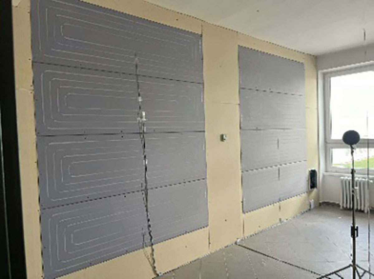 Obr. 5 Realizácia veľkoplošného stenového systému v miestnosti 203 s lokalizáciou snímača tepelného toku 