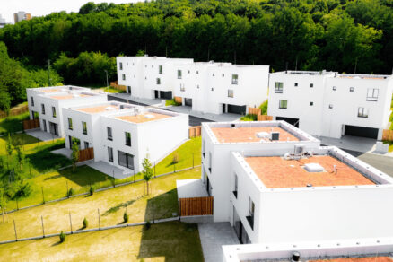 Nová výstavba bielych rodinných domov s minimalistickou architektúrou pri lese