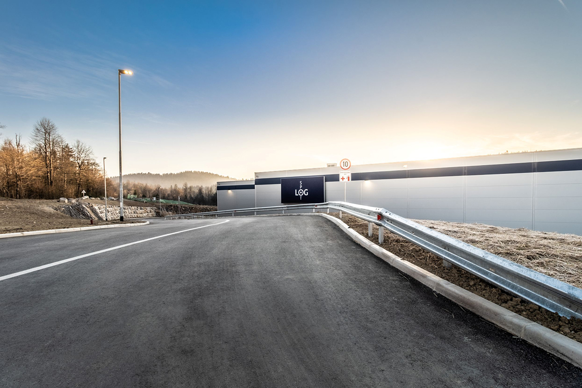 Prístupová cesta k logistickej hale LOGspot v regióne Logatec pri západe slnka