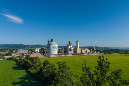 Považská cementáreň Ladce obklopená zeleňou s pohľadom na výrobný areál a silá na cement