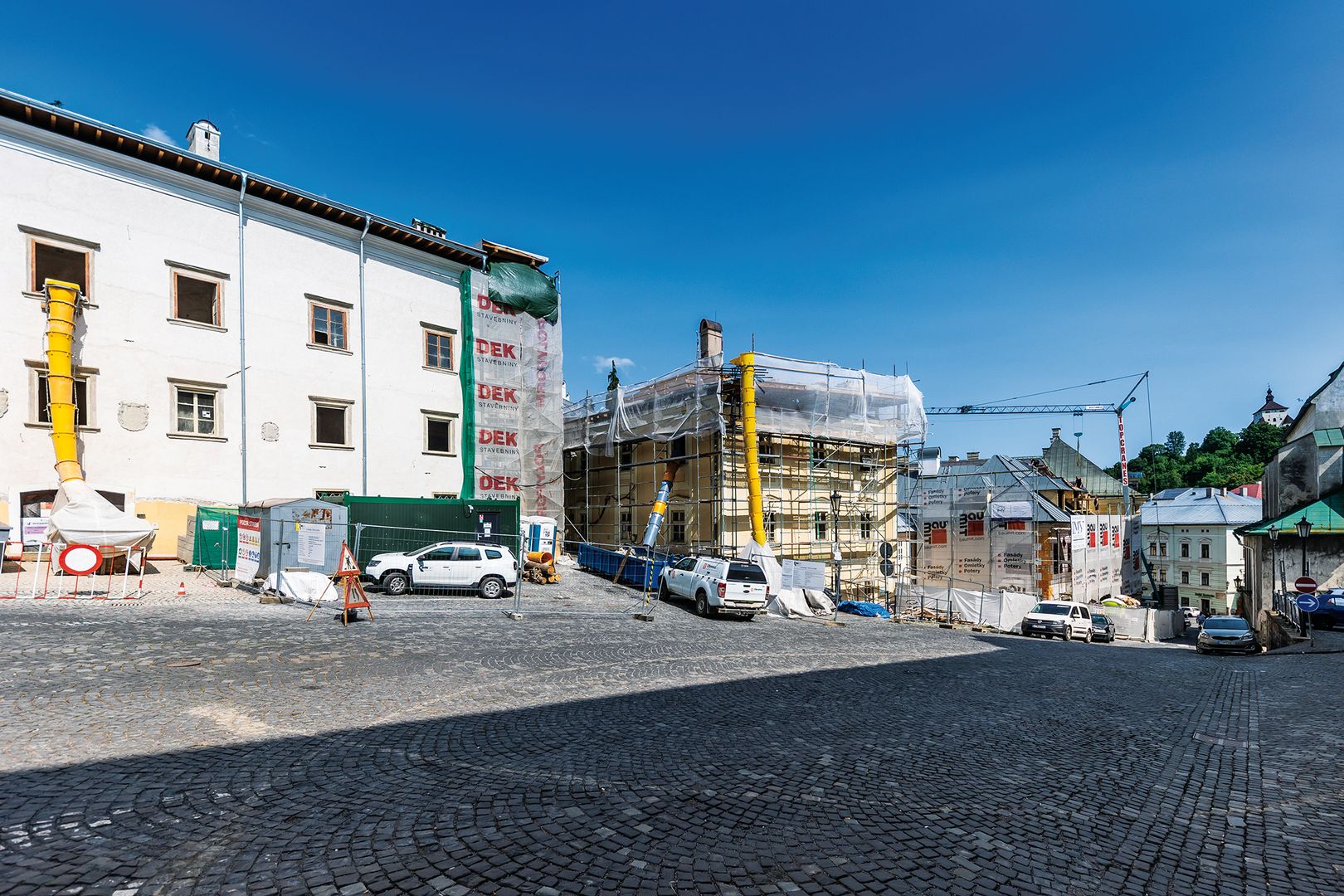 Rekonštrukčné práce v centre mesta na Námestí Sv. Trojice pokračujú, zľava sú Slovenské banské múzeum, základná umelecká škola (Sitnajovský dom) a Pischlov dom (Banka lásky).