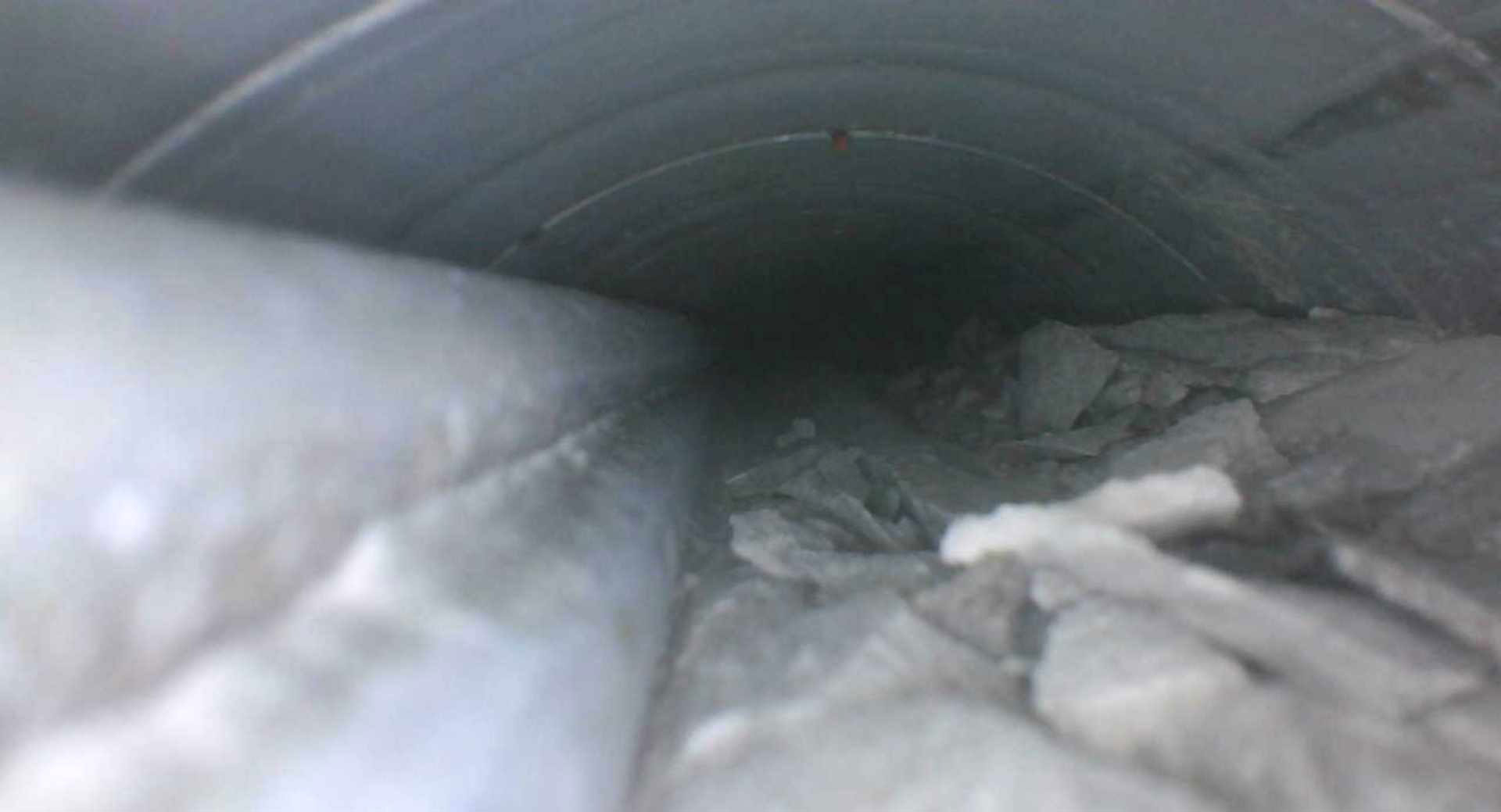 Obr. 6 Veľká dutina v hornej časti kábla – v ľavej časti vidieť predpäté drôty, v pravej časti hladinu rozdrobenej injektážnej malty kriedovitého charakteru.