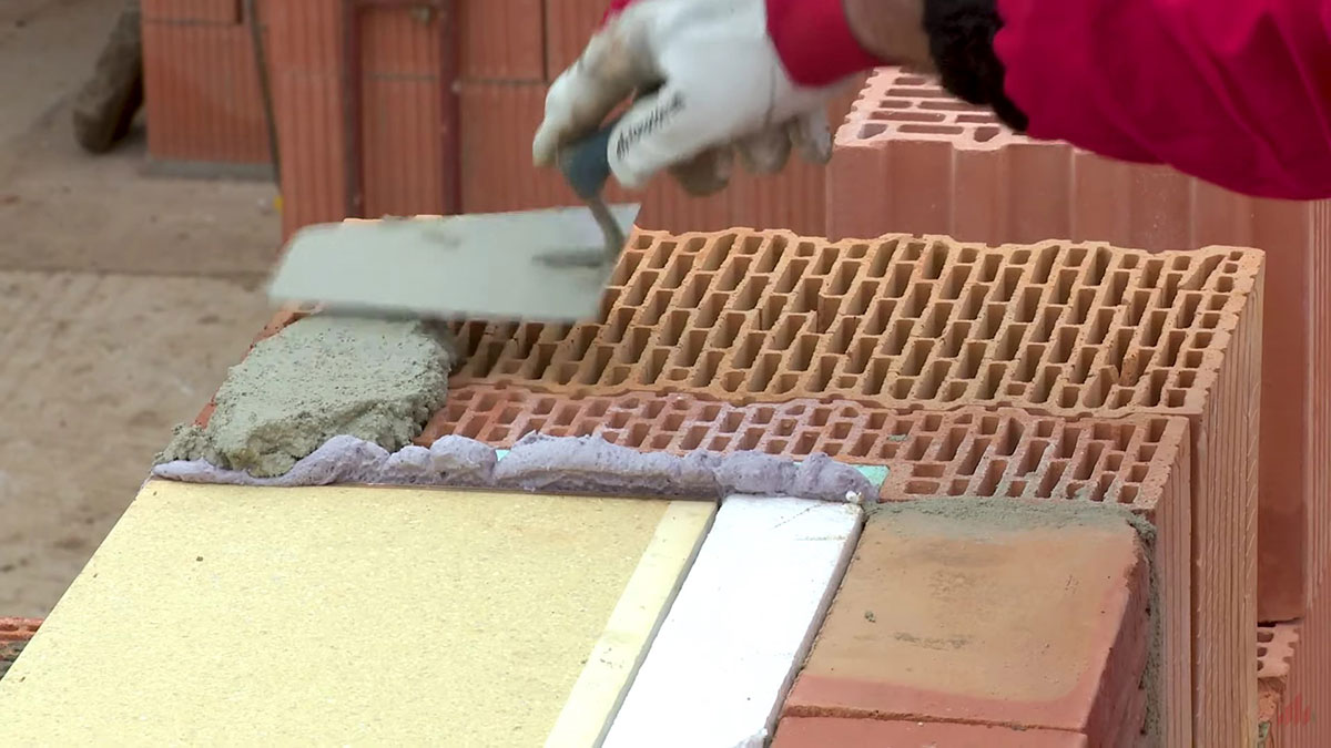 11. Súvisiace prvky a práce: preklad nad schránkou
Vzhľadom na to, že schránka nie je nosný prvok, nesmie na nej spočívať žiadne zaťaženie. Preto nie je možné v týchto miestach použiť napr. vencovú tehlu. Tento detail sa vyrieši tak, že nad schránku sa položí preklad tak, že medzi schránkou a prekladom bude súvislá medzera s hrúbkou približne 10 mm.