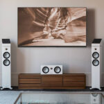 Moderná obývačka so zostavou reproduktorov pre domáce kino Monitor Audio Bronze 7G v bielom prevedení