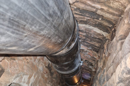 Pohľad zo šikmej šachty (60 × 60 cm) dymovodu (z kotolne) na novo inštalovaný plastový dymovod ALMEVA STARR smerom k pätke komína