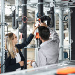Technici nastavujú inteligentný pohon Belimo počas modernizácie vzduchotechniky v budove