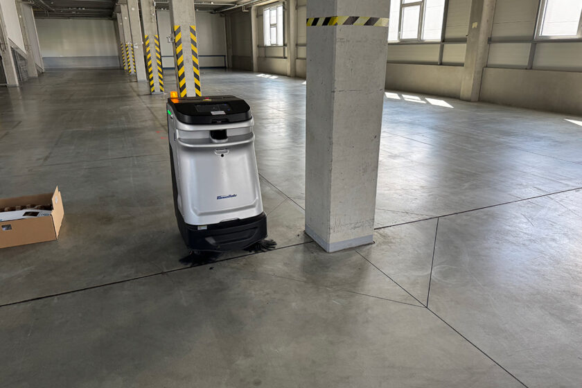 Autonómny čistiaci robot pri práci vo veľkom skladovom priestore