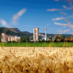 Cementáreň v prírode s poľom v popredí