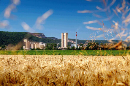 Cementáreň v prírode s poľom v popredí