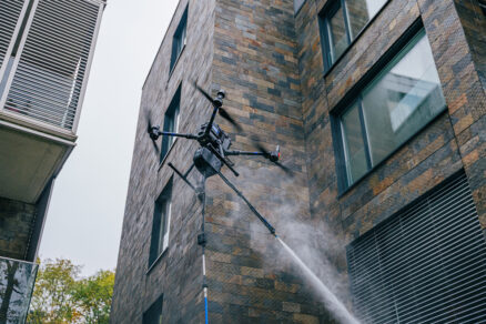 Dron pri čistení fasády administratívnej budovy vysokotlakovým systémom