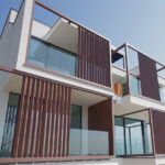 Sklenené zábradlia na modernom rezidenčnom objekte s drevenými lamelami na fasáde