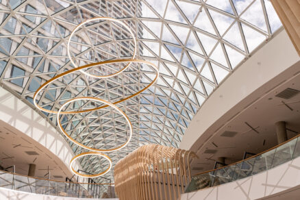 Interiér nákupného centra s celoskleneným zábradlím a presklenou kupolou