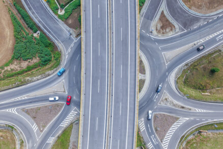Zhora snímaný cestný uzol s viacerými kruhovými objazdmi a nadjazdom na novovybudovanom diaľničnom privádzači