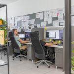 Projektanti a konštruktéri pri práci v moderne vybavenej kancelárii s technickými výkresmi a CAD softvérom.