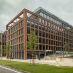 Moderná administratívna budova s tehlovou fasádou po energetickej optimalizácii