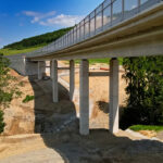 Betónový most s piliermi osadený v krajine, pripravený na montáž mostného záveru