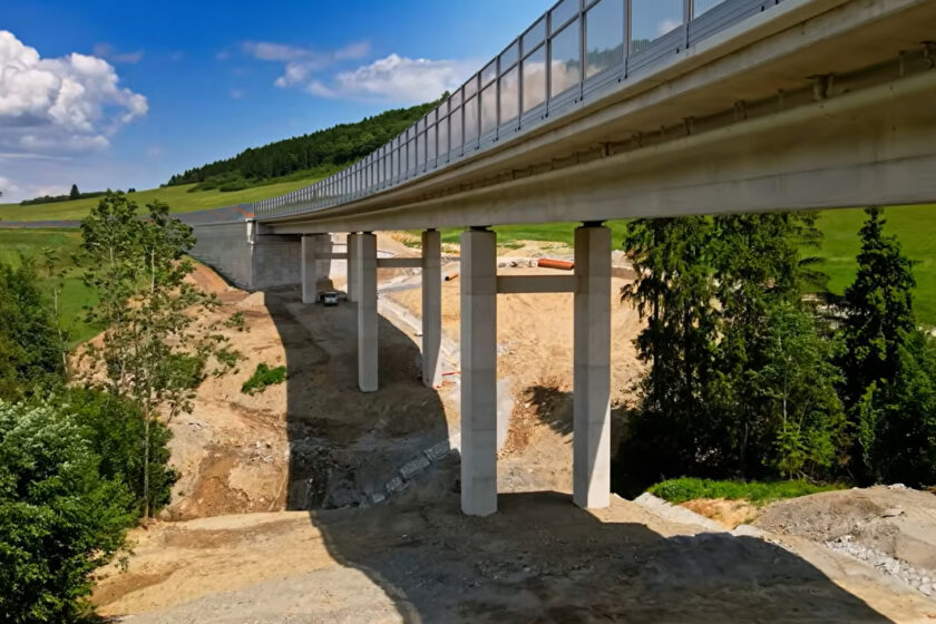 Betónový most s piliermi osadený v krajine, pripravený na montáž mostného záveru