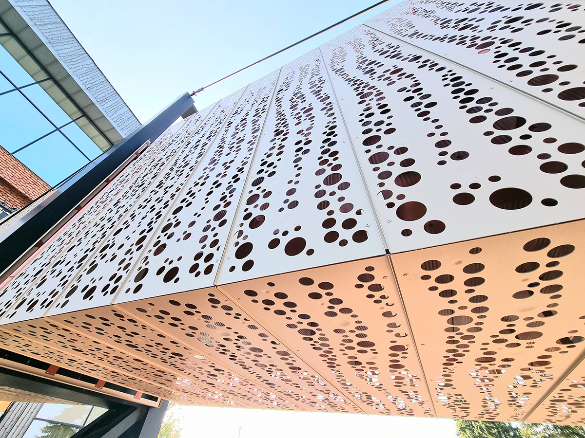 Kovová perforovaná fasáda AVG Moderná kovová fasáda s nepravidelným perforovaným vzorom na administratívnej budove