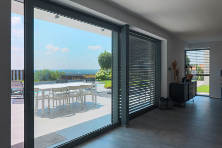 Pohľad z interiéru na záhradu cez zatiahnuté žalúzie